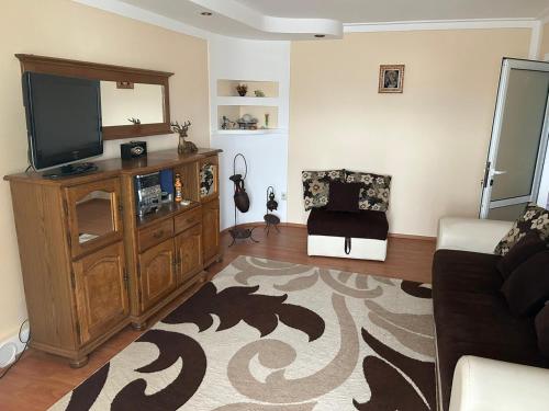 - un salon avec une télévision et un canapé dans l'établissement Apartament Onesti, à Onești