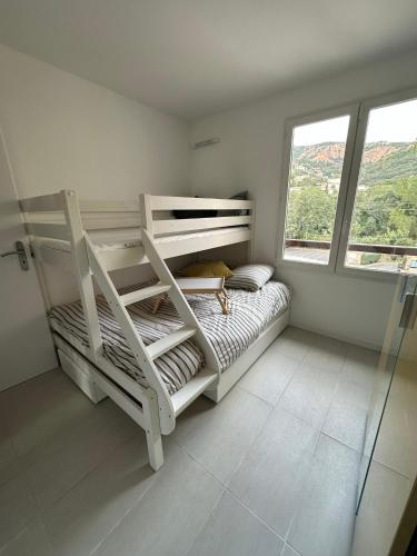 une chambre avec deux lits superposés et une fenêtre dans l'établissement Front de mer, vue exceptionnelle panoramique, à Agay