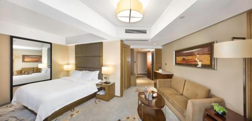 a hotel room with a bed and a couch at The LA Hotel 新世界伟瑞酒店 in Shenzhen
