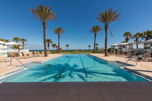 a swimming pool with palm trees in a resort at SouthernVilla Ticket to Paradise in Palm Coast
