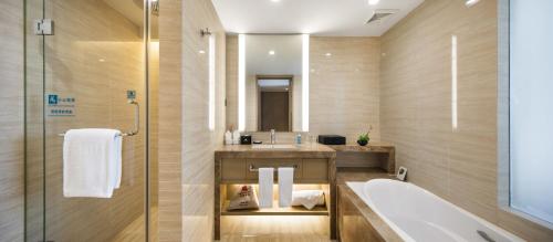 a bathroom with a tub and a sink at The LA Hotel 新世界伟瑞酒店 in Shenzhen