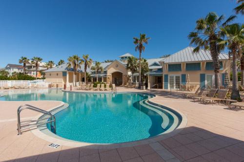 a swimming pool at a resort with palm trees at SouthernVilla Ticket to Paradise in Palm Coast
