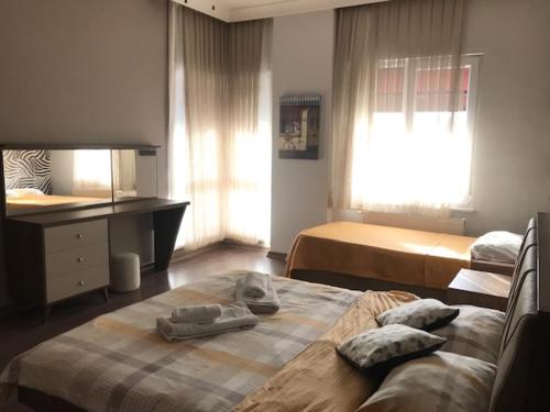 a bedroom with two beds and a desk with towels on them at Güzel Yalı Evleri Residence &Apart Hotel in Atakum