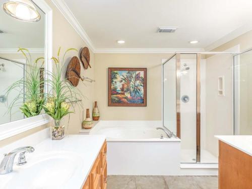 a bathroom with a tub and a sink and a shower at Brass Rail 316 in Tybee Island