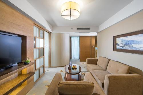 a living room with a couch and a television at The LA Hotel 新世界伟瑞酒店 in Shenzhen