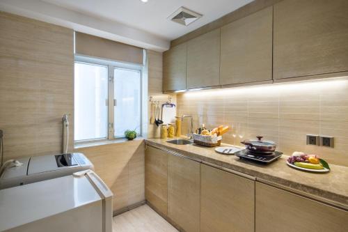 a kitchen with wooden cabinets and a counter top at The LA Hotel 新世界伟瑞酒店 in Shenzhen