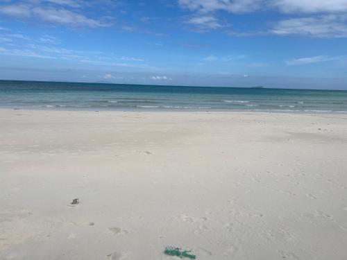 a beach with footprints in the sand and the ocean at JCAH BEACH HOUSE free WiFi in Araceli