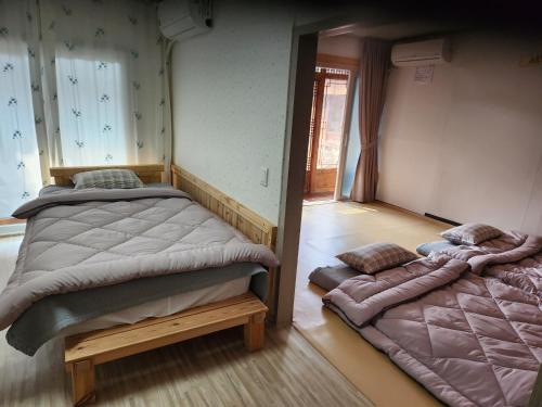 1 dormitorio con 2 camas y espejo en Namuae, en Gyeongju