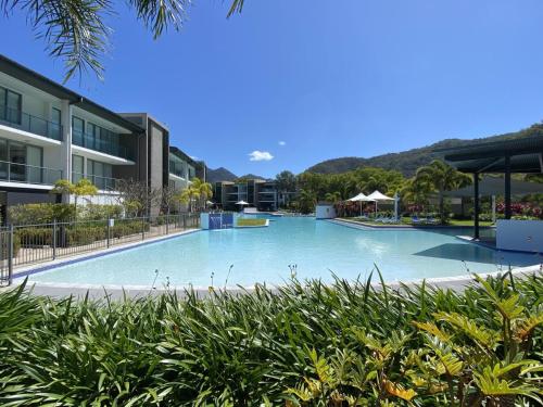 a large swimming pool in front of a building at Blue on Blue Large One Bedroom Apartment, steps from ferry, amazing pool, wifi in Nelly Bay