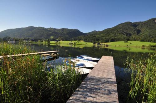 two boats are docked at a dock on a lake at Appartements Herwig Schwarzenbacher in Weissensee