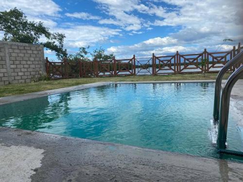 uma piscina com uma cerca de madeira à volta em Cabaña Villa Sol em Tonalá