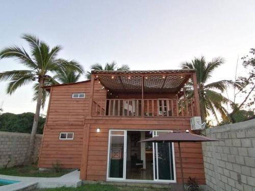 a small wooden house with a balcony on top of it at Cabaña Villa Sol in Tonalá