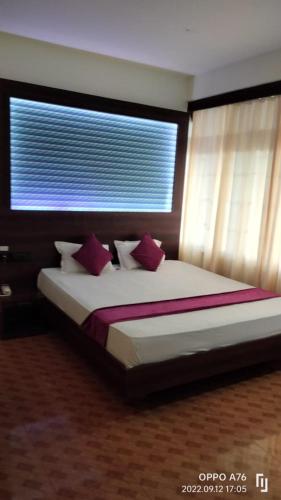 a bedroom with a large bed with a window at LILY GUEST HOUSE in Shillong