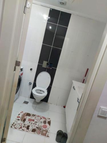 a bathroom with a toilet and black and white tiles at اسطنبول اسنيورت ستار تاورز in Esenyurt
