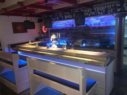 a bar with a counter and two chairs in a room at Hotel Friesengeist in Wiesmoor