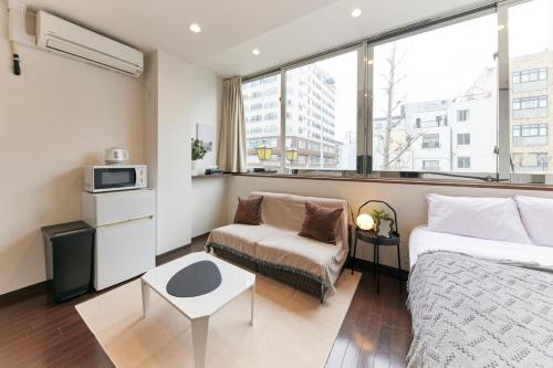 a bedroom with a bed and a chair and a window at ZEROSHARE CHIKKO in Osaka