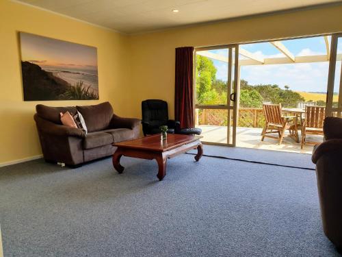 a living room with a couch and a coffee table at Tealuca Holiday Home in Ngataki