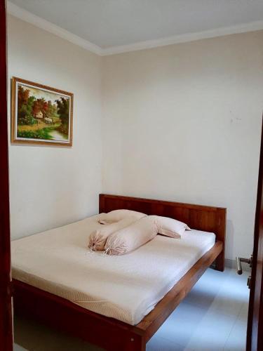 a bed in a room with avertisement at Joglo Rahayu Homestay in Timuran