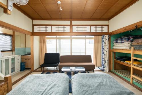 Destiny Inn Sakaiminato في ساكايميناتو: غرفة معيشة بها سريرين وأريكة