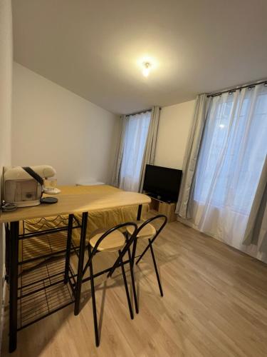 a room with a desk and two chairs and a television at Studio meaux hyper centre in Meaux