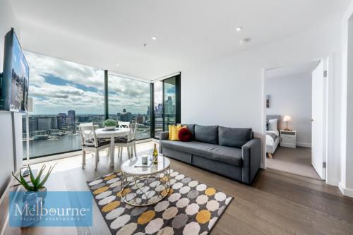 a living room with a couch and a table at Melbourne Private Apartments - Collins Wharf Waterfront, Docklands in Melbourne