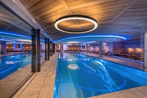 a large swimming pool in a hotel with a ceiling at Alpinhotel Berghaus spa in Tux