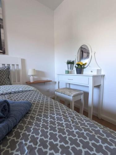 a bedroom with a bed and a dressing table and a mirror at Ferienwohnung für 4 Gäste in Grömitz in Grömitz