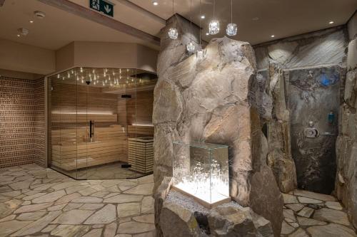 a bathroom with a large stone wall and a shower at Hotel Bismarck in Bad Hofgastein