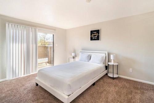 a white bedroom with a large bed and a window at LuxCation At Med Center Free Parking & WIFI in Houston