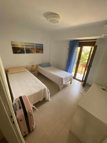 a bedroom with two beds and a window at Aristotelis Apartment in Nikiti