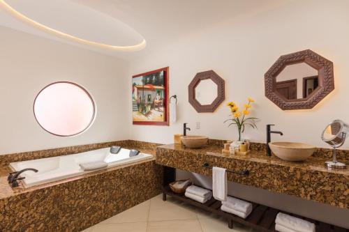a bathroom with two sinks and a tub at Villas At Hacienda Encantada in Cabo San Lucas