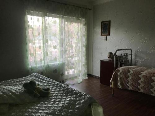 un osito de peluche sentado en una cama en un dormitorio en House 125a en Dilijan