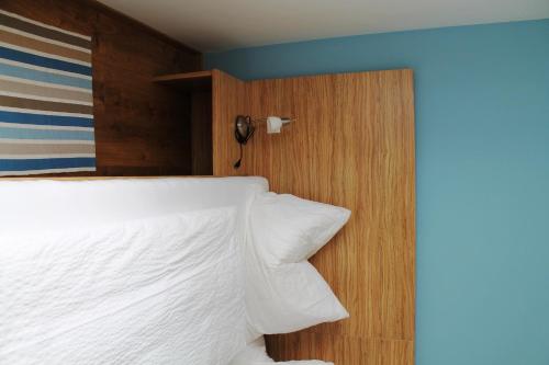 a bedroom with a bed with white sheets and a wooden wall at Ferienhof Weingut Lunzer in Gols