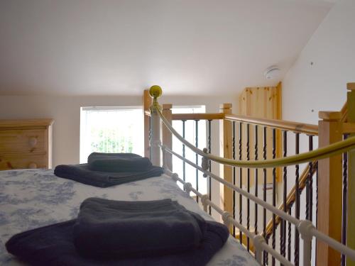 a bedroom with two beds and a stair railing at The Snuff Box in Clenchwarton