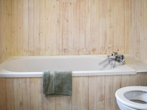 a bathroom with a bath tub and a toilet at The Snuff Box in Clenchwarton