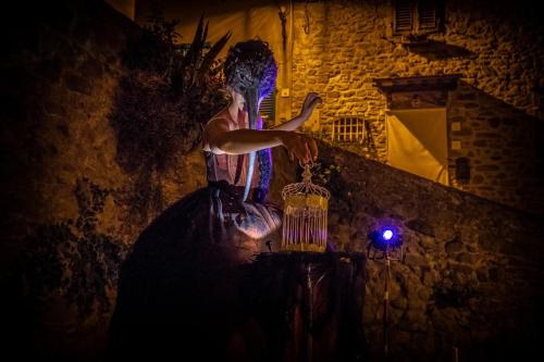 a man standing next to a wall at night at Casa Collodi Castello in Collodi