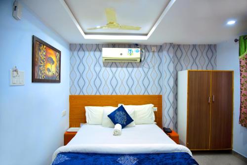 a bedroom with a bed with a blue and white at Hotel Housefinch Residency in Bangalore