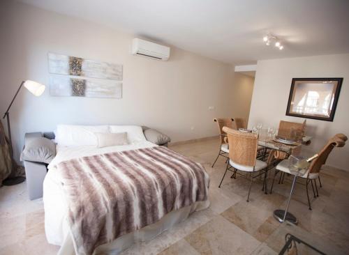 1 dormitorio con 1 cama, mesa y sillas en Ático portofino, en Almerimar