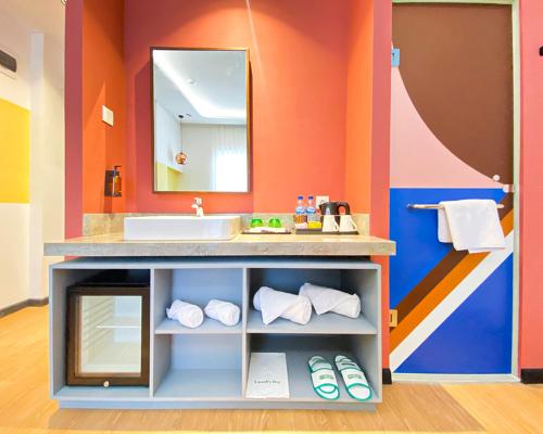 a bathroom with a sink and a mirror at Parkside Alhambra Hotel Banda Aceh in Banda Aceh