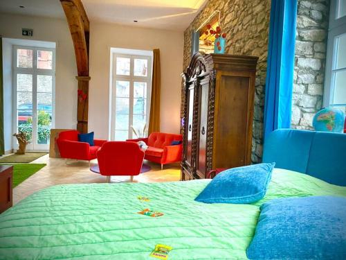 a bedroom with a bed with red chairs and a stone wall at Altstadt pur!An der wunderschönen Katharinenkirche in Oppenheim