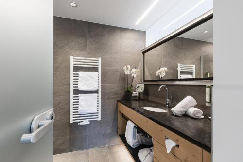 a bathroom with a sink and a mirror at Aktiv Panoramahotel Daniel in Sautens