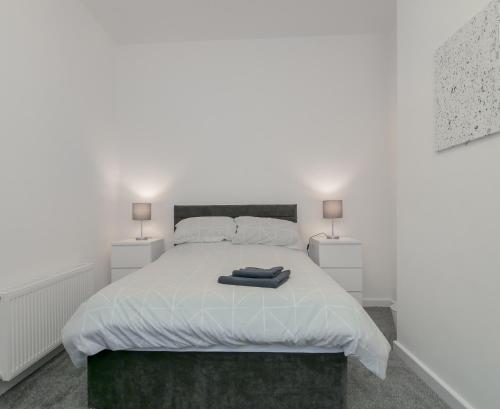 a bedroom with a white bed with two lamps at Apex Living NE - Carnegie House 4 Bed House, FREE PARKING FREE WiFi 