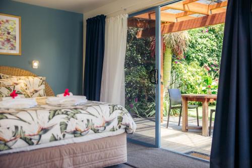 a bedroom with a bed and a patio with a table at Futuna Rocks Motel in Kaikoura