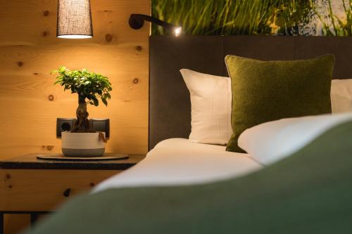 a bedroom with a bed and a plant on a table at Aktiv Panoramahotel Daniel in Sautens