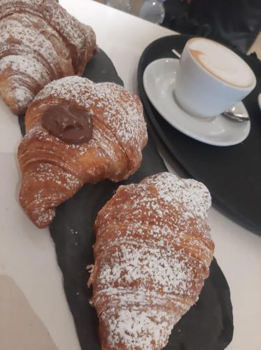 a plate with two pastries and a cup of coffee at Hotel Castelfidardo in Rome