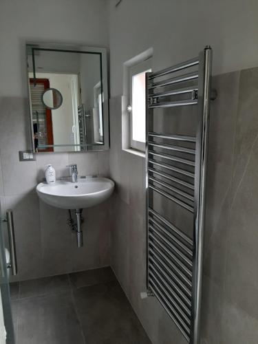 een badkamer met een wastafel en een spiegel en een douche bij Casa Shanty in La Spezia