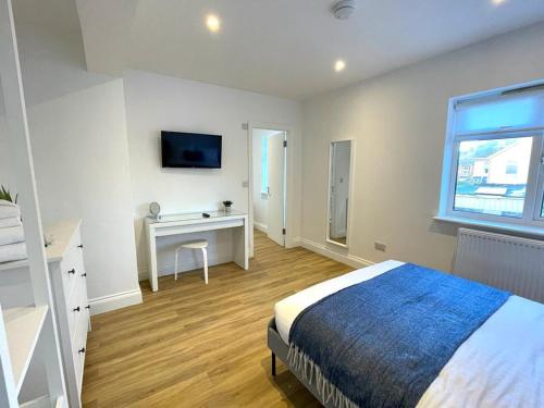 a bedroom with a bed and a desk and a window at Ivory House in Gorleston-on-Sea
