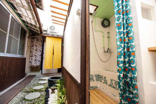 a small hallway with a shower and a tub at Guesthouse Bon in Kyoto