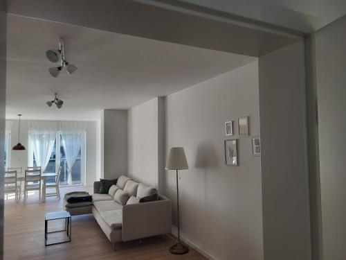 Apartment in Plankstadt في Plankstadt: غرفة معيشة مع أريكة بيضاء وطاولة