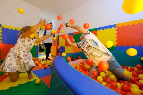 two girls playing with balls in a play room at Parc Hotel Du Lac in Levico Terme